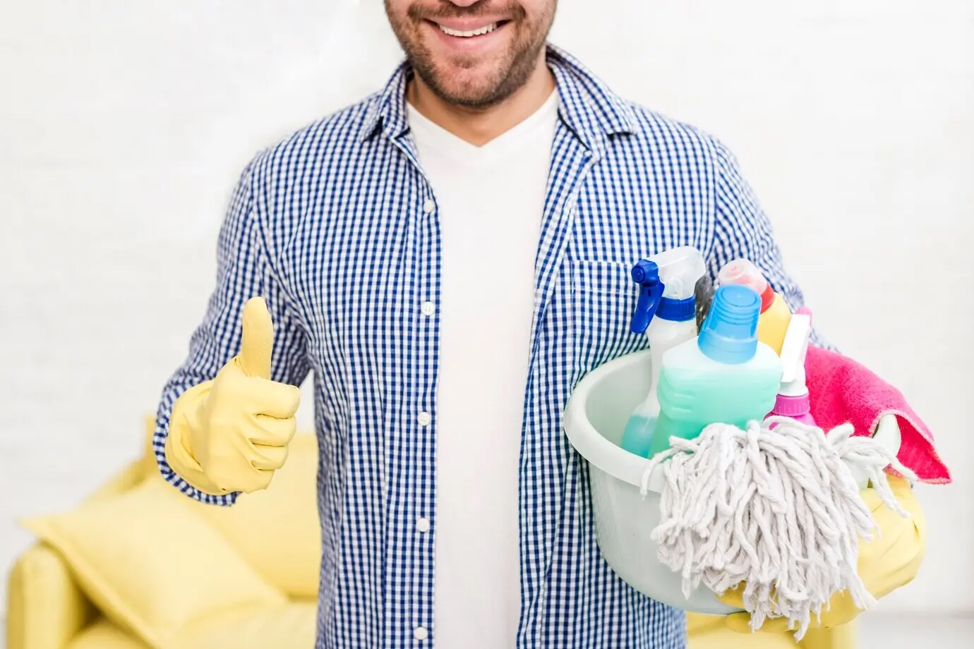 Мужчина показывает большой палец вверх, держа в руках чистящие средства.