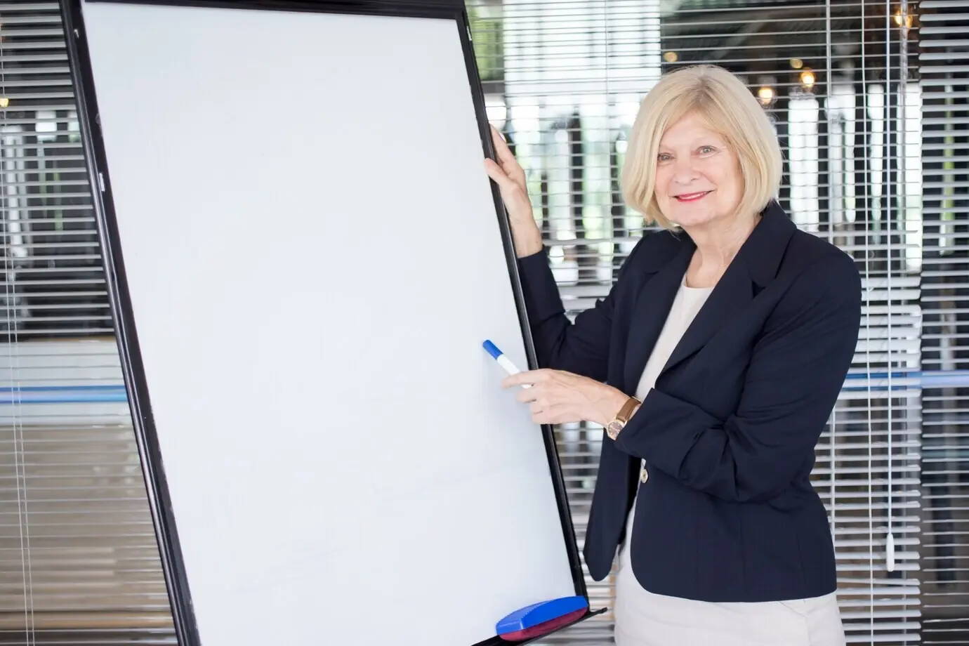 Улыбающаяся пожилая руководительница объясняет задачу.